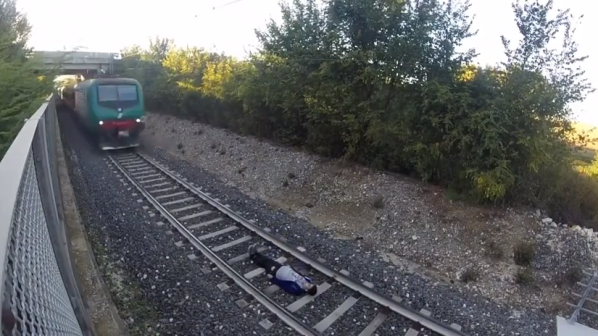 Момче ляга под релсите на влак (видео)