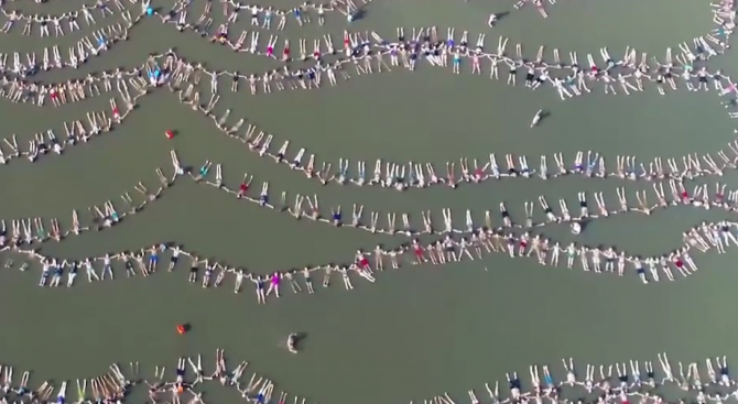 1941 души се хванаха за ръце и плуваха в редица (видео)
