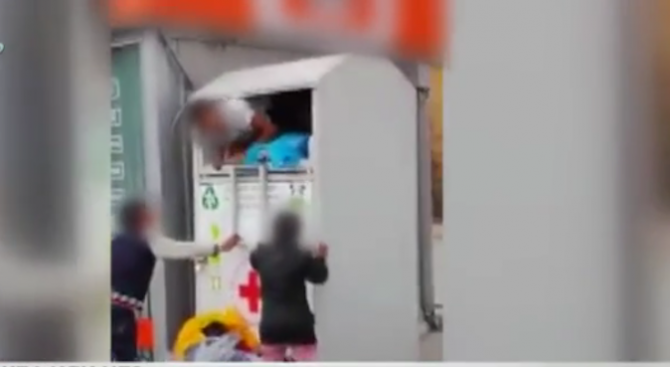 Деца вадят дрехи от дарителски контейнер на БЧК в София
