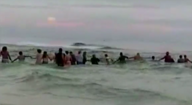 Плажуващи направиха жива верига във водата и успяха да спасят цяло семейство от удавяне (видео)
