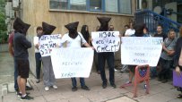 С черни маски и вързани ръце граждани протестират пред НЗОК